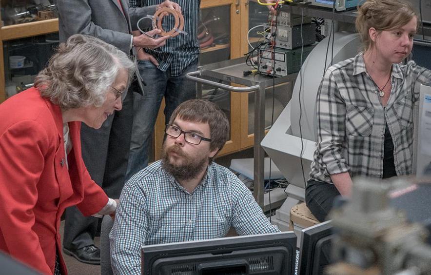 Students work in a research lab with faculty members